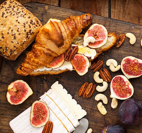 photo of a delicious croissants with figs, nuts and cheeses