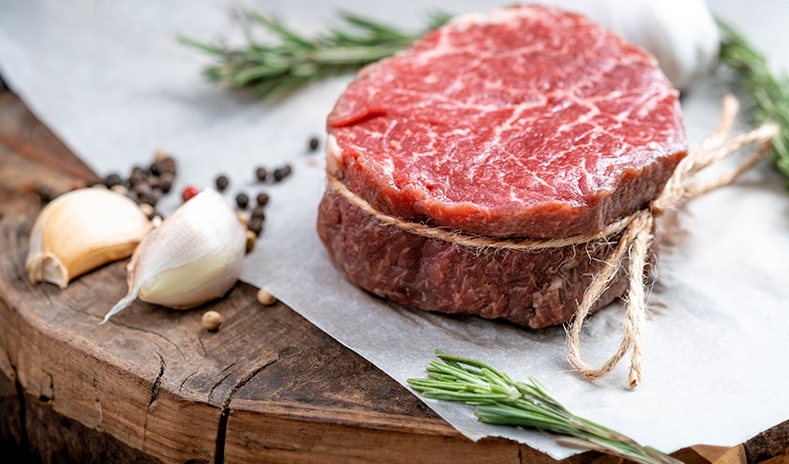 Delicious image of filet mignon steak on wooden board with garlic